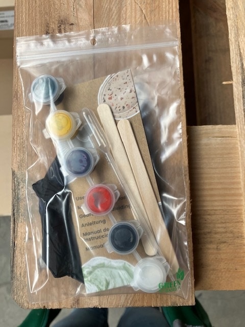 Een samengestelde kit van Unicraft. De kit zit in een plastieken zakje en bevat onder andere mengstokjes, kleine potjes verf en een handleiding.